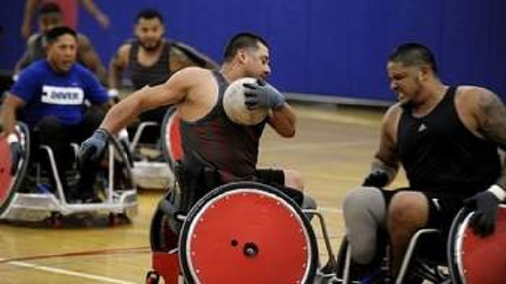 Team U.S. wheelchair rugby player with ball Sgt. Eric Rodriguez, (medically retired), tries to roll through traffic during a training session at the gymnasium on MacDill AFB. They will compete next week in the international Invictus games held in Orlando. JAY CONNER/STAFF